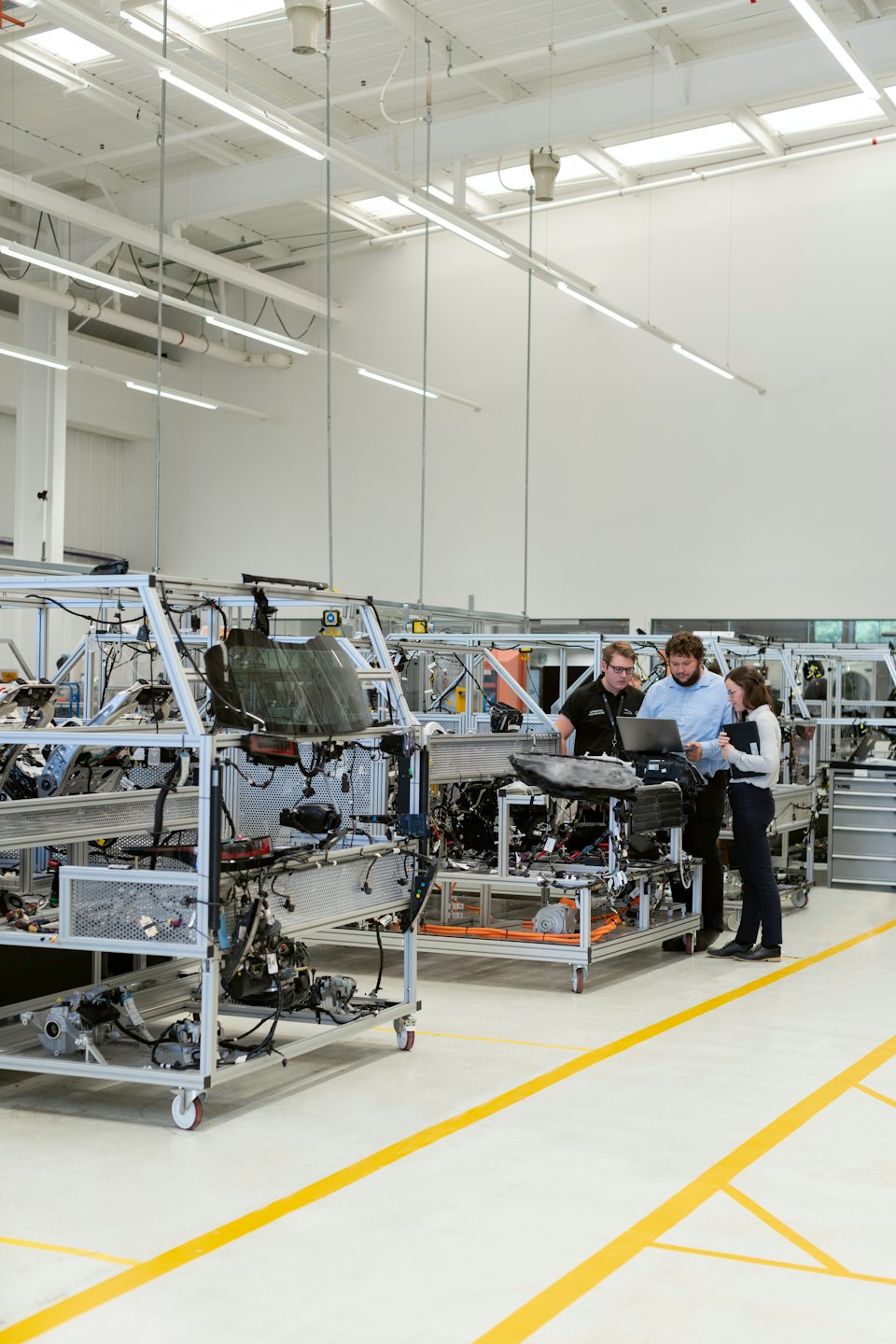 Engineers collaborating around a laptop at a factory.
